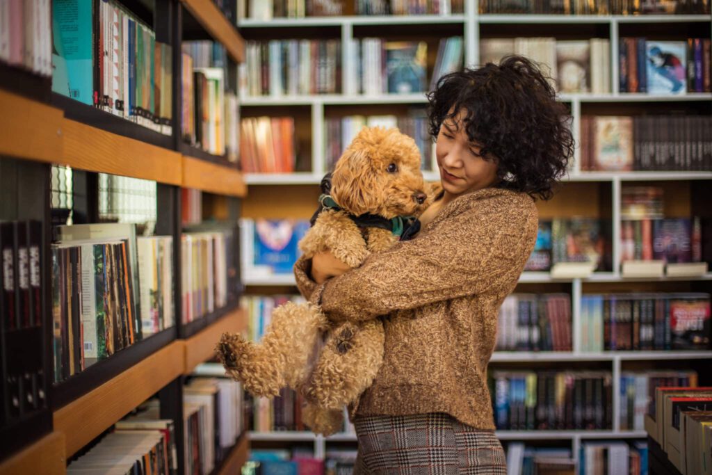 Frau mit Hund in Bücherei